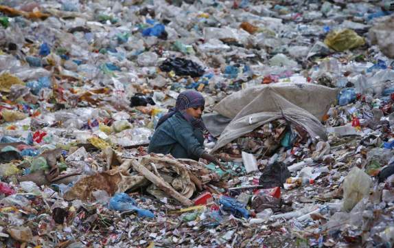 A boy sorts out recyclables from a dumping ground at a slum in Karachi