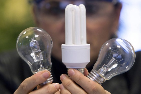 An employee shows a traditional light bulb and two low-energy consumption bulbs at the Osram factory in Molsheim