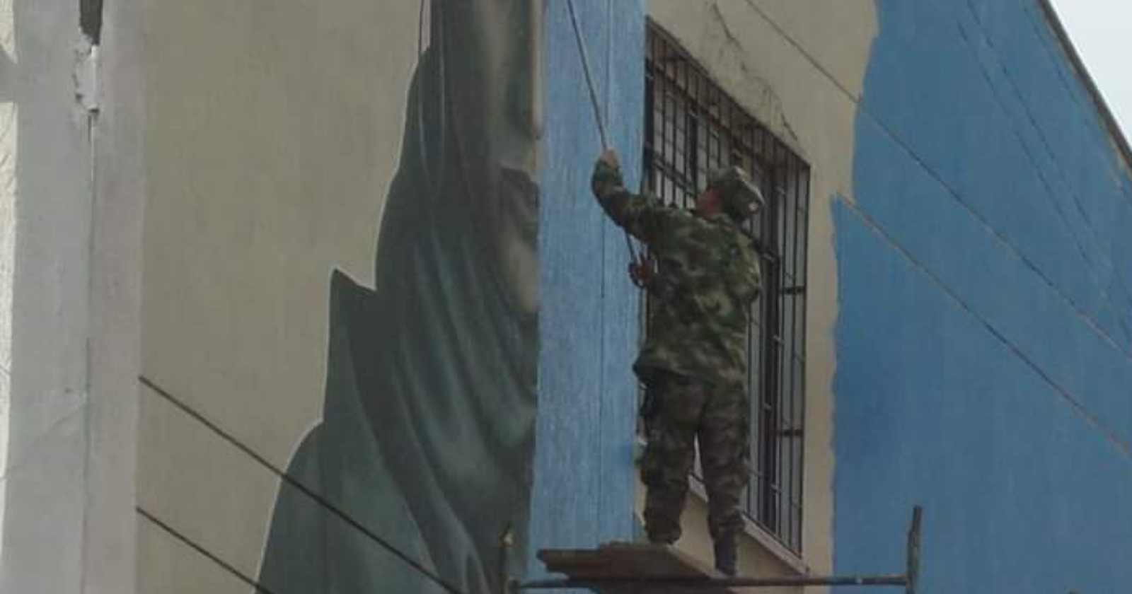 militares borrando mural